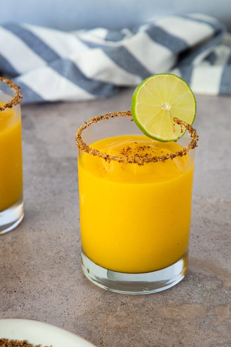 Frozen mango margarita with a chili-salt rim and lime slice garnish.