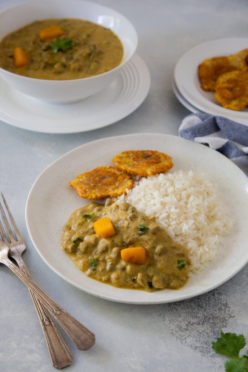 White rice topped with guandules con coco and tostones.